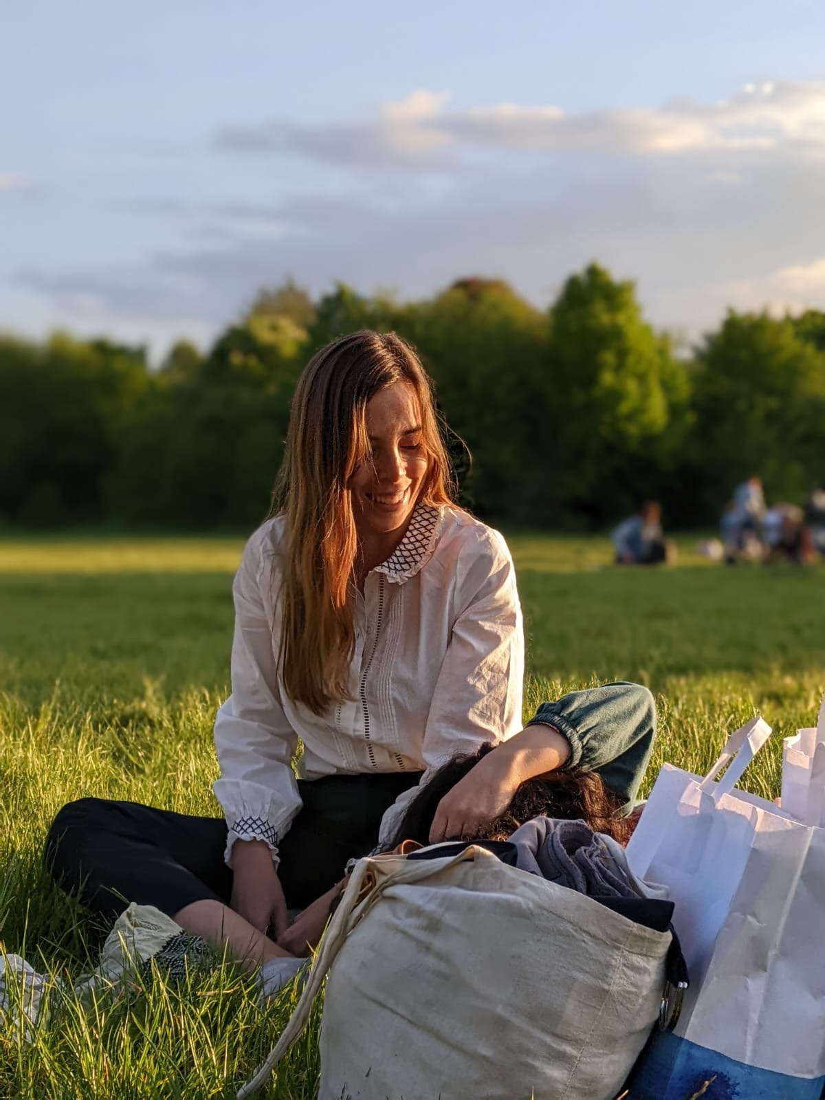 Alana Brito sitting in a park at golden hour
